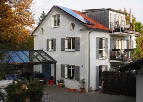 a white house with an orange roof at Ferienwohnung Meding am See in Schondorf am Ammersee