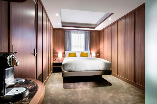 a hotel room with a bed and a window at Hougoumont Hotel Fremantle in Fremantle