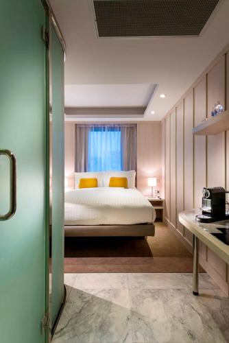 a bedroom with a bed and a window at Hougoumont Hotel Fremantle in Fremantle
