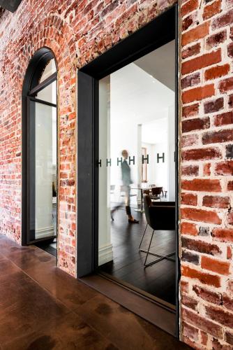 a brick wall with a mirror in a room at Hougoumont Hotel Fremantle in Fremantle