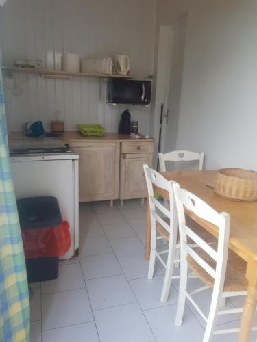 eine Küche mit einem Tisch, 2 Stühlen und einem Tisch in der Unterkunft Les Gites L'archipel - gite Les Saintes in Saint-Claude