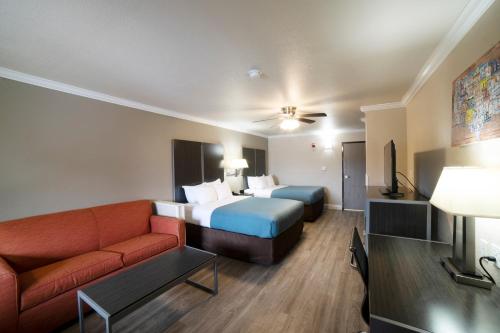 コーパスクリスティにあるEcono Lodge Inn & Suites Corpus Christiのベッドとソファ付きのホテルルーム