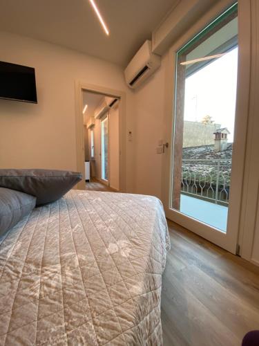 una camera con un letto e una grande finestra di Welcome Traveller BORSATI'S APARTMENTS a Garda