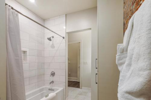 a bathroom with a shower and a tub and a sink at The St John in New Orleans