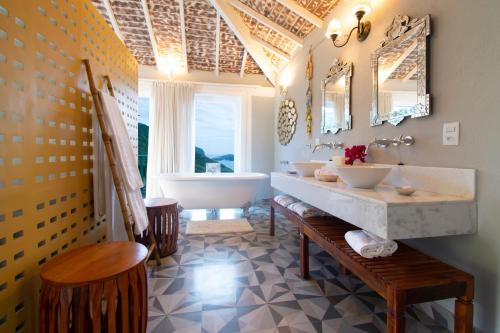 布希奧斯的住宿－Pedra da Laguna Boutique Hotel SPA，浴室配有两个盥洗盆和浴缸。