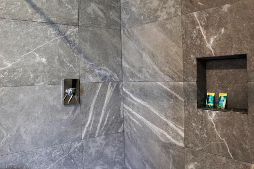 baño con pared de piedra y 2 dispensadores de jabón en Suites ciento 37, en León