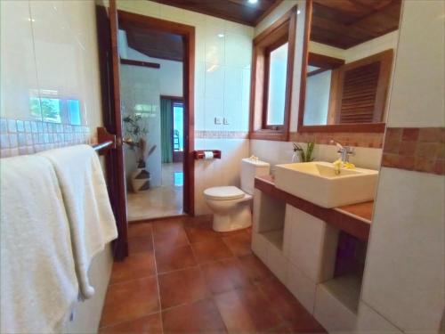 a bathroom with a white sink and a toilet at Absolute Beachfront, Paradise, 3BR Villa with Private Pool on 1200m2 of Tropical Land in Tulamben