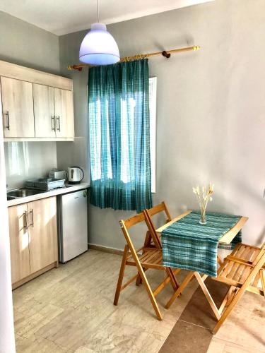 a kitchen with a table and two chairs and a table and a kitchen with at Banos Apartment 2 bed rooms And Swimming Pool in Roda