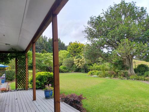 a covered porch with a yard with a tree at Dangela Boutique Lodge in Auckland