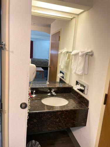 a bathroom with a sink and a mirror at Super 8 by Wyndham Fort Worth Downtown South in Fort Worth
