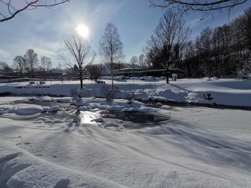 a river covered in snow with the sun in the background at Willa Katarzynka in Wisła