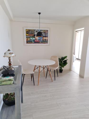 a white living room with a table and chairs at AMUNATEGUI 213 Centro Iquique Ejecutivos in Iquique