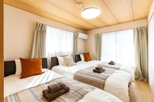Duas camas num quarto com janelas em ASAHI HOUSE 2nd floor - Vacation STAY 92921 em Naha