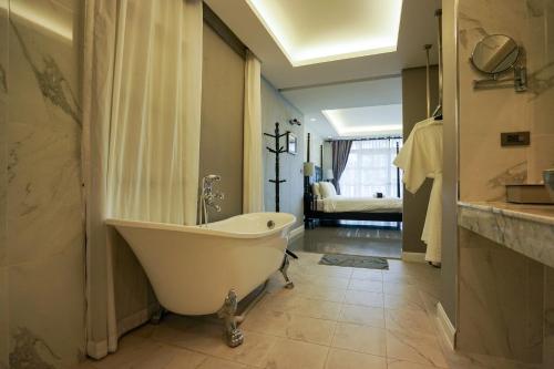 a bathroom with a bath tub and a sink at Casa VESPA at WUA LAI Boutique Hotel Chiang Mai in Chiang Mai