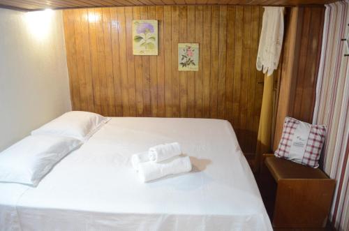 a bedroom with a bed with two towels on it at Casa do Lago in Gramado