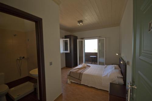 sypialnia z łóżkiem oraz łazienka z umywalką w obiekcie Lefkas Petra w mieście Agios Nikitas