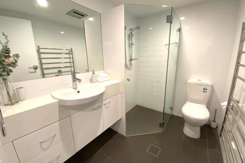 a bathroom with a toilet and a sink and a shower at Steamboat Unit 1 in Thredbo