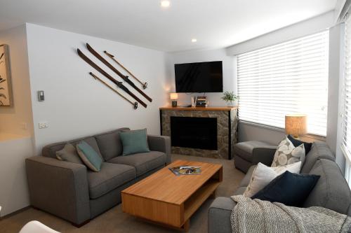 a living room with two couches and a fireplace at Steamboat Unit 1 in Thredbo