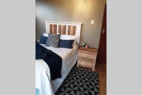 a bedroom with a bed with blue and white pillows at Cabins Sodwana Bay - antibootika in Sodwana Bay