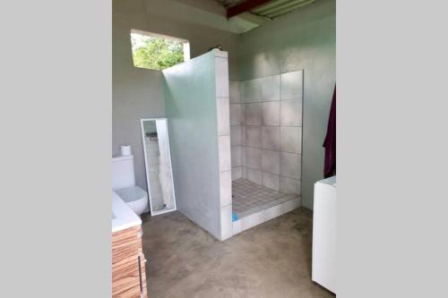 a bathroom with a shower with a toilet and a sink at Cabins Sodwana Bay - antibootika in Sodwana Bay