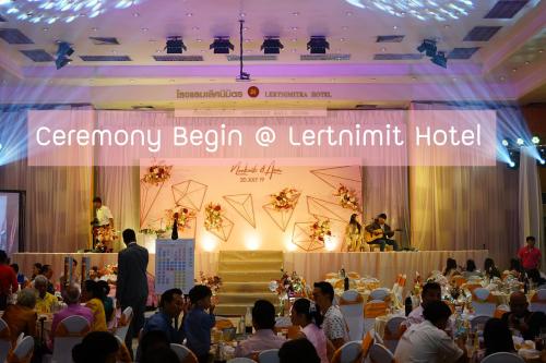 a crowd of people sitting in a room with a stage at Lertnimit Hotel in Chaiyaphum