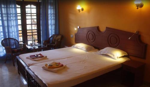 a bedroom with a large bed with two plates of food on it at Anitha's Garden Stay in Kovalam