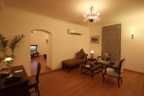a living room with a chandelier and a living room at Amritara Suryauday Haveli in Varanasi