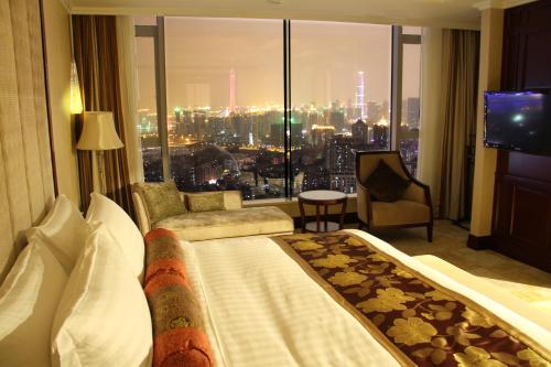 a hotel room with a bed and a view of a city at Soluxe Hotel Guangzhou - Overseas Buyers Registration Service&Canton Fair Free Shuttle Bus 15 Oct to 04 Nov in Guangzhou