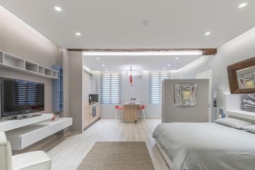 ボローニャにあるMANDRIA APARTMENTS 1 2の白いベッドルーム(ベッド1台、テレビ付)