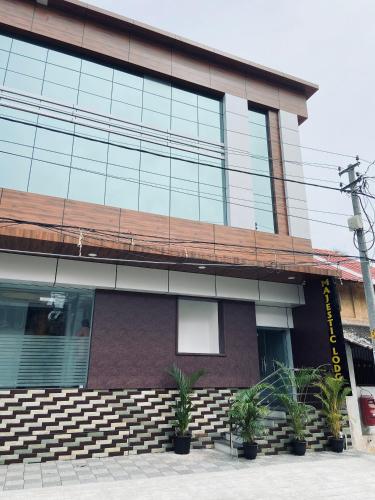 a building with potted plants in front of it at Majestic Inn in Trivandrum