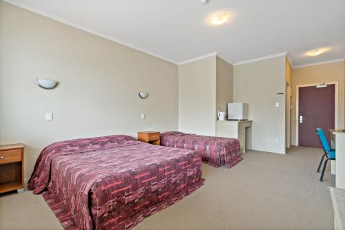 a hotel room with two beds and a table at Essex Arms in Huntly