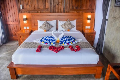 a bed with a heart made out of flowers on it at Japa Guesthouse in Canggu