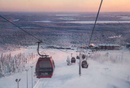 um grupo de esquiadores a andar de teleférico na neve em Holiday in Lapland - Ylläs Gondola apartment, huoneisto 6207 em Ylläsjärvi