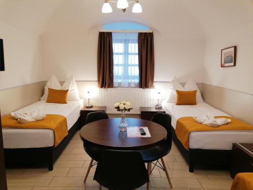 ヤースベレニにあるRiver Apartmanházのベッド2台とテーブルが備わるホテルルームです。