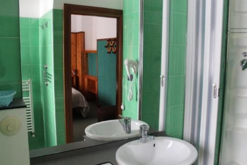 a green bathroom with a sink and a mirror at Hotel La Piccola Baita in Terminillo