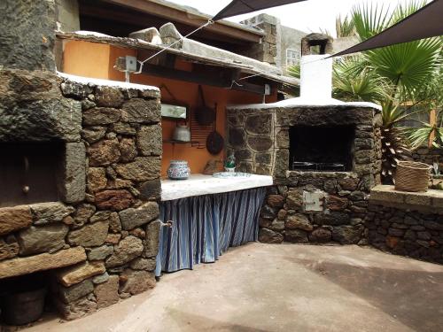 a stone kitchen with a sink in a stone wall at Le casette di Marilena Agave Iucca in Pantelleria
