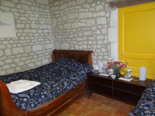 a bedroom with a bed and a table with flowers at gîte du manoir des roches in Saires