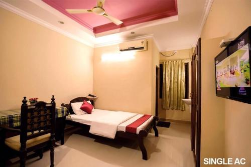 a bedroom with a bed and a tv in a room at Surabhi Suites in Angamaly