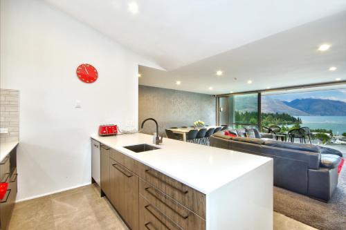 a kitchen and living room with a view of the ocean at Luxury on the Lake in Queenstown