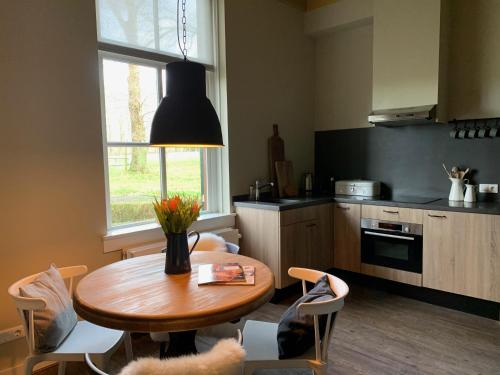 a kitchen with a wooden table and a dining room at Herberg de Pas in Haarle