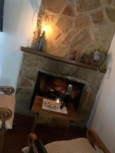 a stone fireplace with a table in front of it at Apartamentos Rurales Peralta in Segura de la Sierra