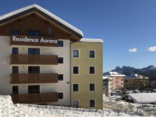 a building with aresuranceagency sign on it in the snow at Residence Aurora in Lavarone