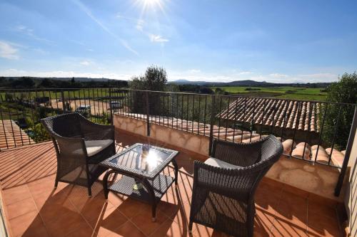 a patio with three chairs and a table on a balcony at Agroturisme Es Racó De Maria in Maria de la Salut