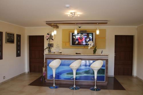 a large fish tank in a room with two stools at Willa Laura Rowy - Apartamenty nad morzem in Rowy