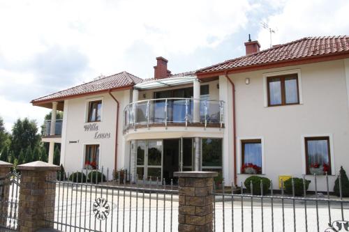 a large white house with a wrought iron fence at Willa Laura Rowy - Apartamenty nad morzem in Rowy