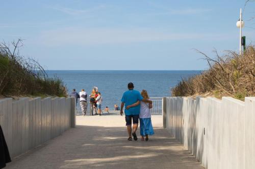 a man and a woman walking down the beach at Willa Laura Rowy - Apartamenty nad morzem in Rowy