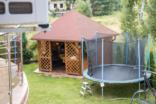 a gazebo with a trampoline in the yard at Willa Laura Rowy - Apartamenty nad morzem in Rowy