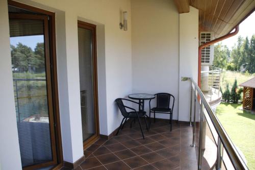 a balcony with a table and chairs on it at Willa Laura Rowy - Apartamenty nad morzem in Rowy