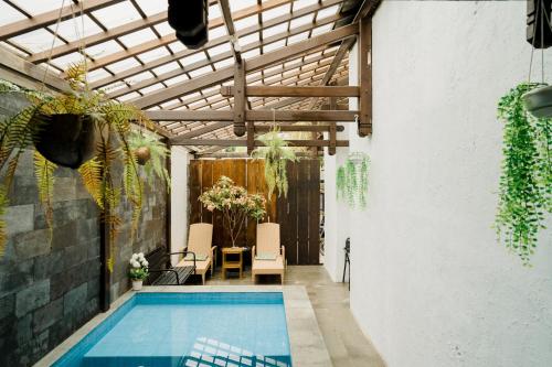 una piscina in un edificio con soffitto in legno di OstiC House a Yogyakarta