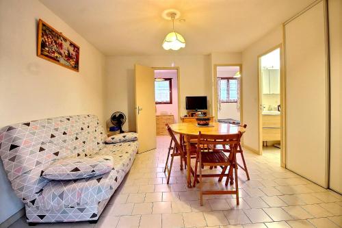 ein Wohnzimmer mit einem Sofa und einem Tisch in der Unterkunft Pavillon indépendant pour 6 personnes dans une résidence sécurisée avec piscine in Valras-Plage